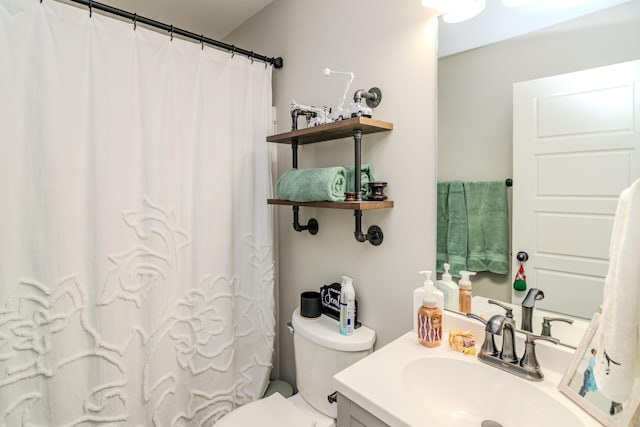 bathroom with curtained shower, toilet, and vanity