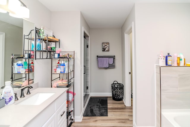 bathroom featuring vanity, a tub, and hardwood / wood-style floors