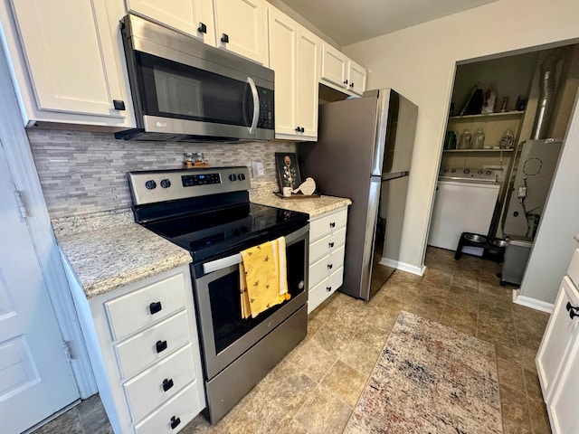 kitchen featuring washer / dryer, white cabinets, backsplash, stainless steel appliances, and light stone countertops