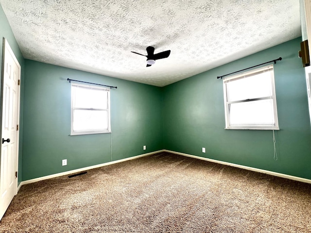 unfurnished room with a textured ceiling, ceiling fan, and carpet