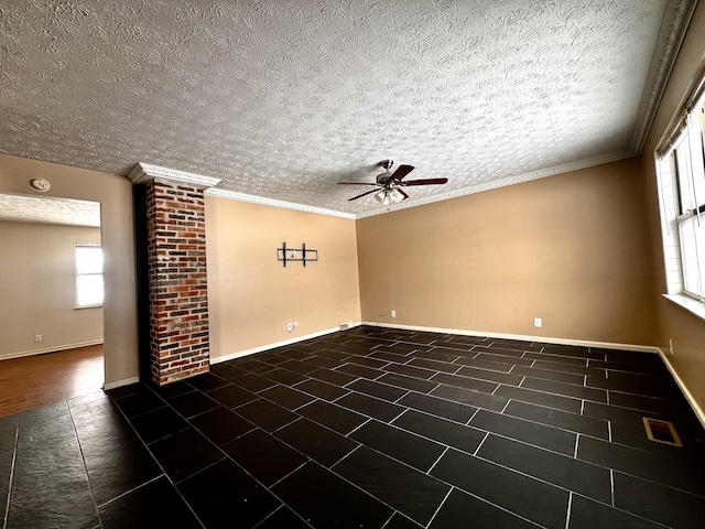 empty room featuring ornamental molding, a textured ceiling, dark tile patterned flooring, and ceiling fan