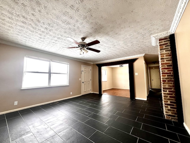 spare room with a textured ceiling, ornamental molding, and ceiling fan