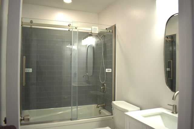 full bathroom with vanity, shower / bath combination with glass door, and toilet