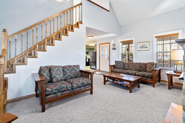 carpeted living room with high vaulted ceiling