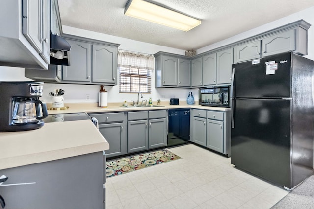 kitchen featuring gray cabinetry, black appliances, ventilation hood, sink, and a textured ceiling