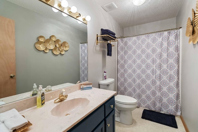 bathroom with vanity, toilet, and a textured ceiling