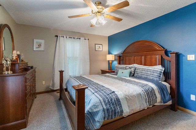 carpeted bedroom with ceiling fan and a textured ceiling