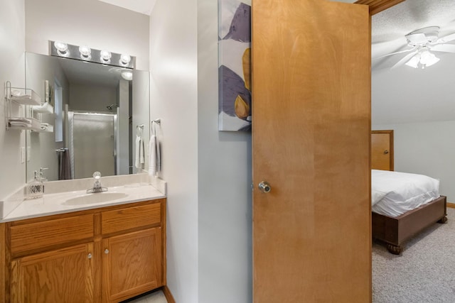 bathroom featuring ceiling fan, a shower with shower door, a textured ceiling, and vanity