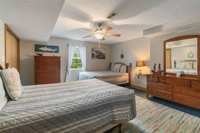 bedroom with carpet flooring, a textured ceiling, and ceiling fan