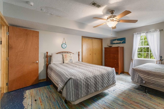 bedroom featuring ceiling fan, a closet, and a textured ceiling