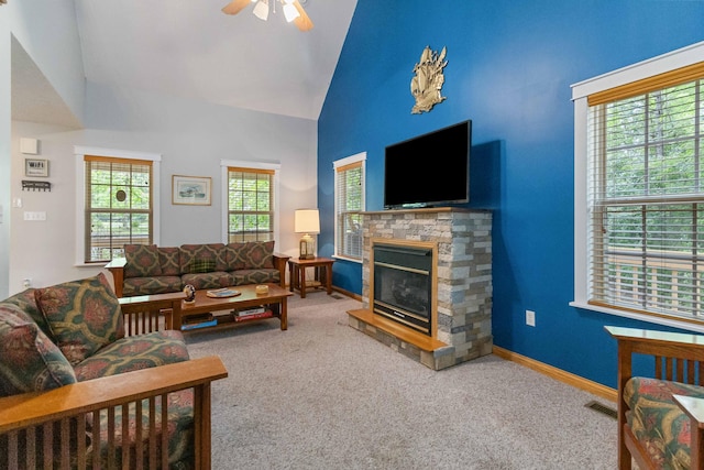 living room with carpet floors, high vaulted ceiling, a stone fireplace, and ceiling fan