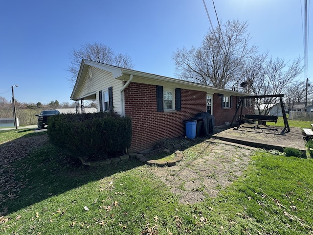 view of side of home featuring a patio and a lawn