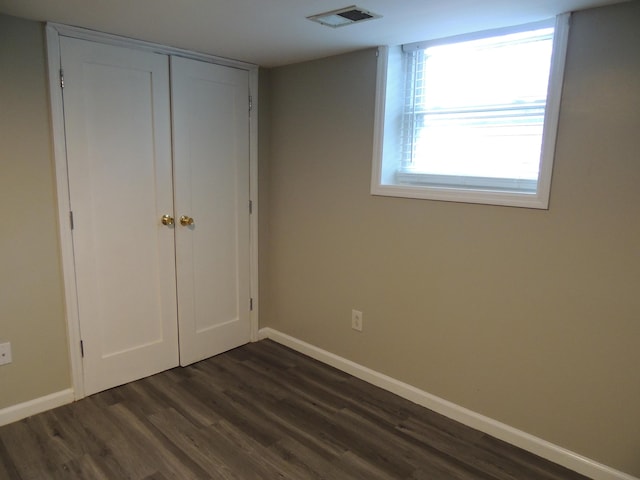 unfurnished bedroom featuring dark hardwood / wood-style flooring and a closet