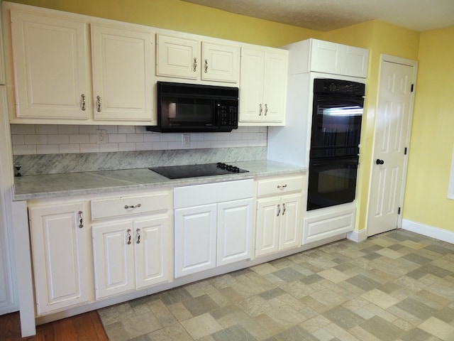 kitchen with black appliances, white cabinetry, and backsplash