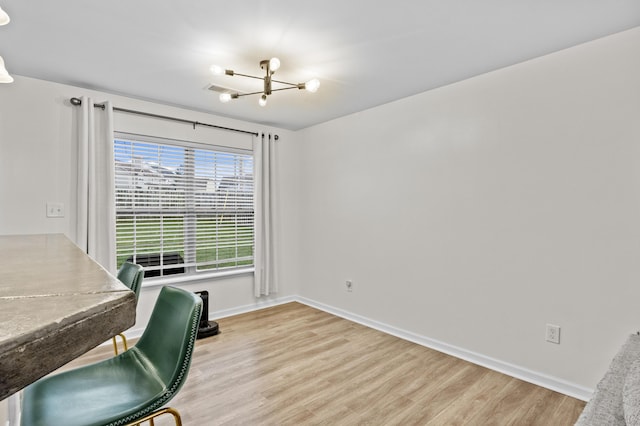 home office featuring light hardwood / wood-style flooring and an inviting chandelier