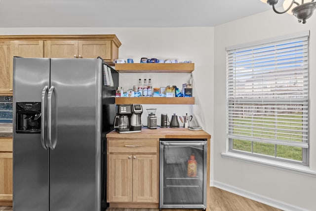 bar featuring light wood-type flooring, stainless steel fridge with ice dispenser, and wine cooler