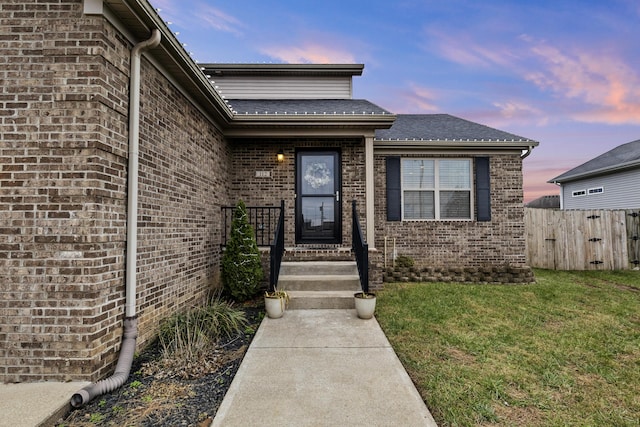 exterior entry at dusk with a lawn