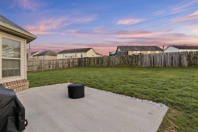 patio terrace at dusk with grilling area and a lawn