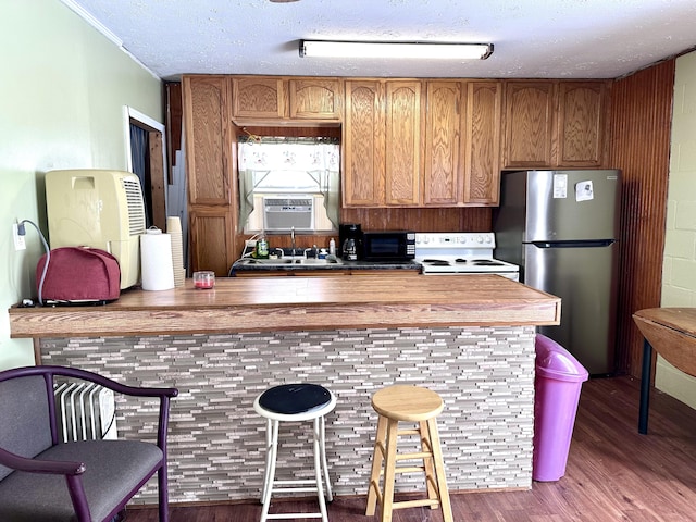 kitchen featuring stainless steel refrigerator, cooling unit, hardwood / wood-style flooring, a textured ceiling, and electric stove