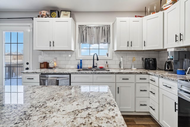 kitchen featuring backsplash, white cabinetry, and sink