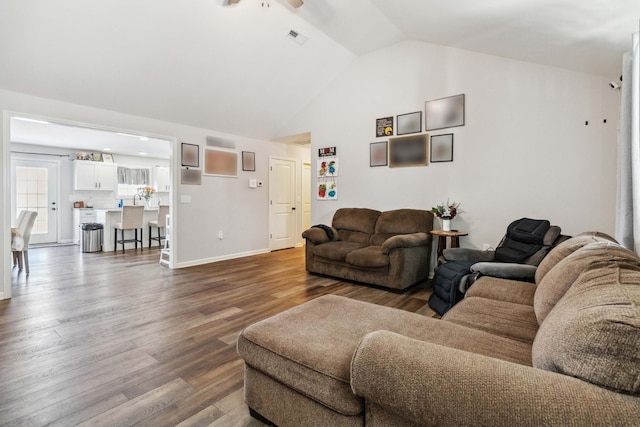 living room with hardwood / wood-style flooring, ceiling fan, and vaulted ceiling