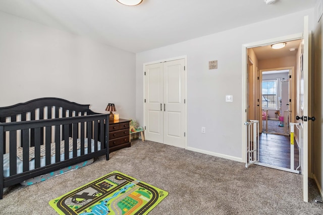 bedroom with a crib, carpet, and a closet