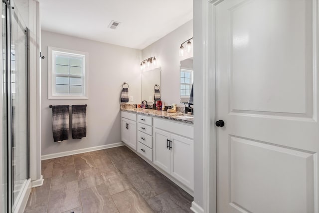 bathroom with vanity and a shower with door