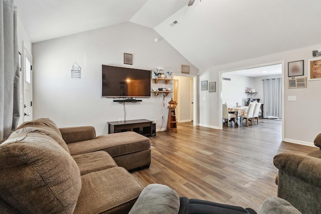 living room featuring wood-type flooring and vaulted ceiling