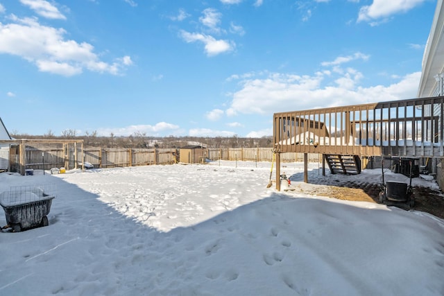 yard covered in snow featuring a shed and a wooden deck