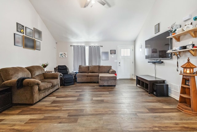 living room with vaulted ceiling, ceiling fan, and dark wood-type flooring