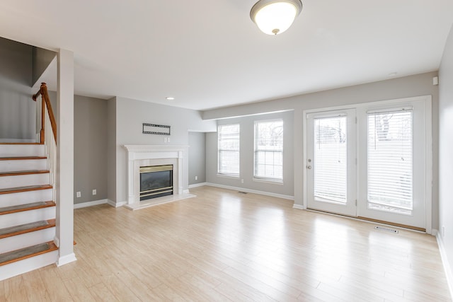 unfurnished living room with light wood-type flooring and a premium fireplace