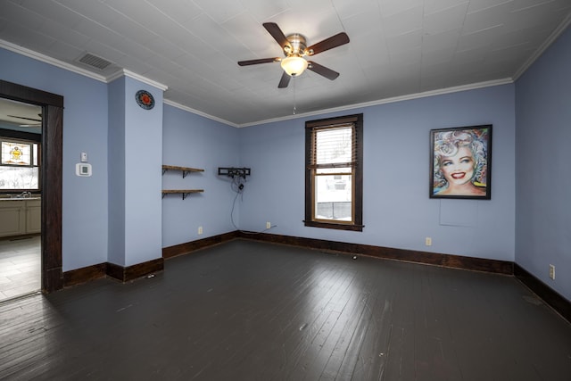 spare room with visible vents, baseboards, a ceiling fan, ornamental molding, and dark wood finished floors