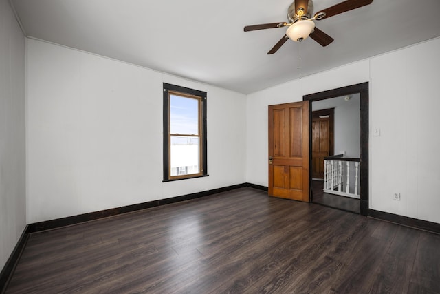 spare room featuring vaulted ceiling, dark wood finished floors, baseboards, and ceiling fan