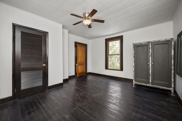 unfurnished bedroom featuring dark wood-style floors, crown molding, baseboards, and ceiling fan