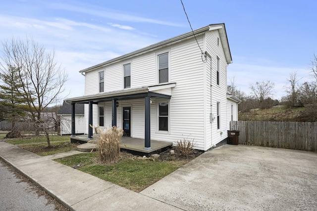 view of front of house featuring fence and a porch