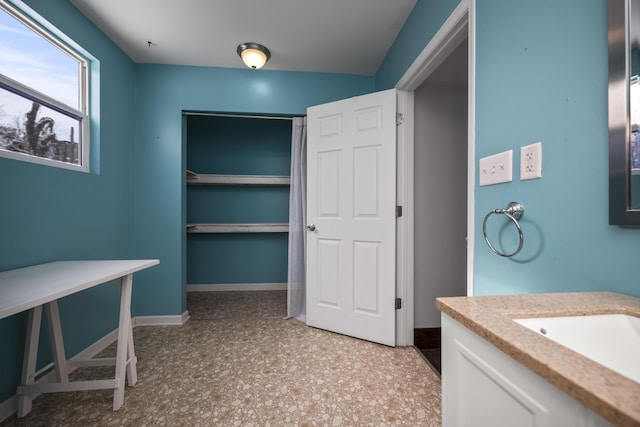 bathroom with tile patterned floors, baseboards, and vanity