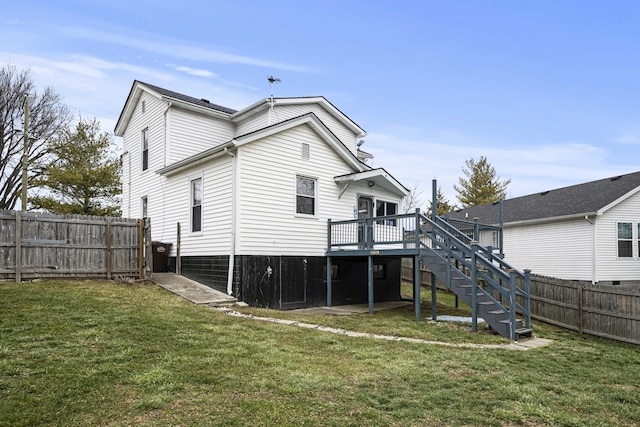 rear view of house featuring stairs, fence, a lawn, and a wooden deck