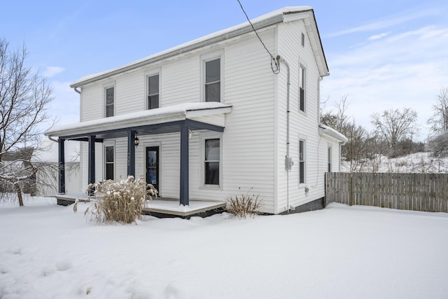 traditional-style home with a porch and fence