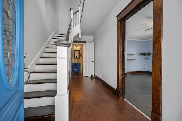 stairway featuring crown molding, baseboards, and wood finished floors