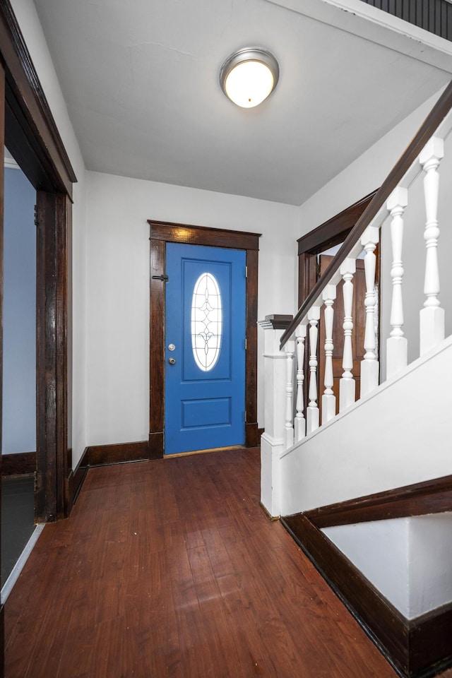 entrance foyer with stairs, baseboards, and dark wood finished floors