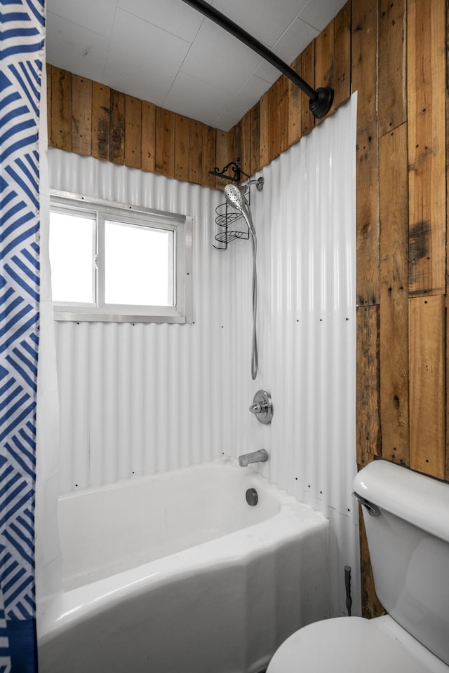 full bathroom with shower / washtub combination, wooden walls, and toilet