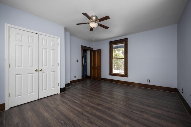 unfurnished bedroom featuring dark wood-style flooring, a closet, a ceiling fan, and baseboards