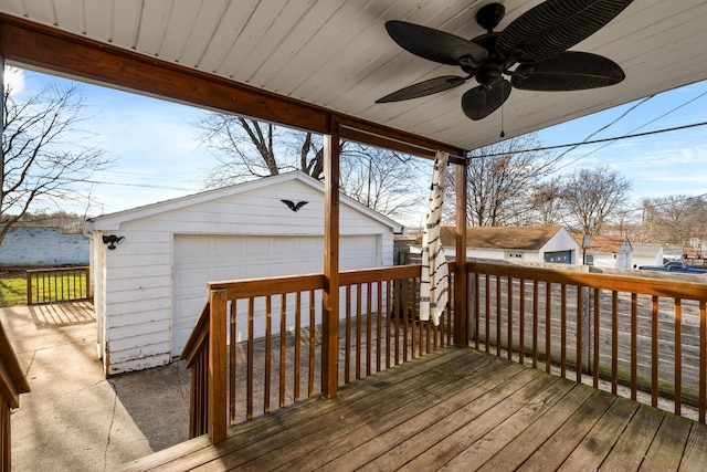 wooden terrace with an outbuilding, a garage, and ceiling fan