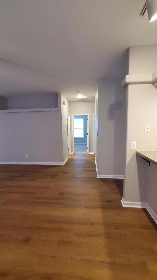 hallway featuring baseboards and wood finished floors