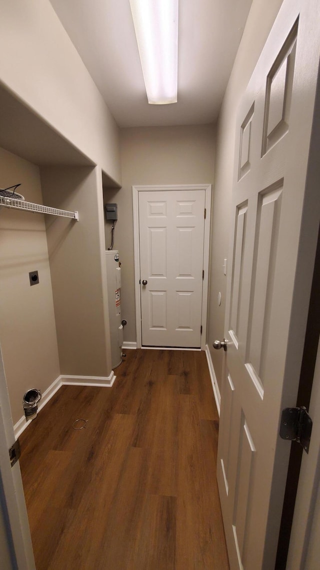 clothes washing area featuring wood finished floors, baseboards, hookup for an electric dryer, laundry area, and water heater