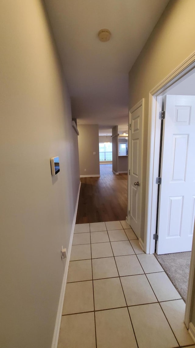 hallway featuring light tile patterned floors and baseboards