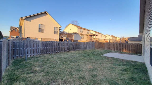 view of yard featuring a patio area, a fenced backyard, and a residential view