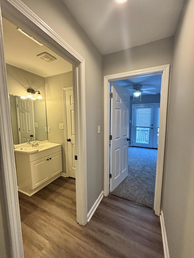 hall with dark hardwood / wood-style flooring and sink