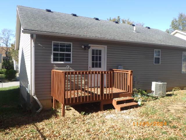 rear view of house with a deck and central AC