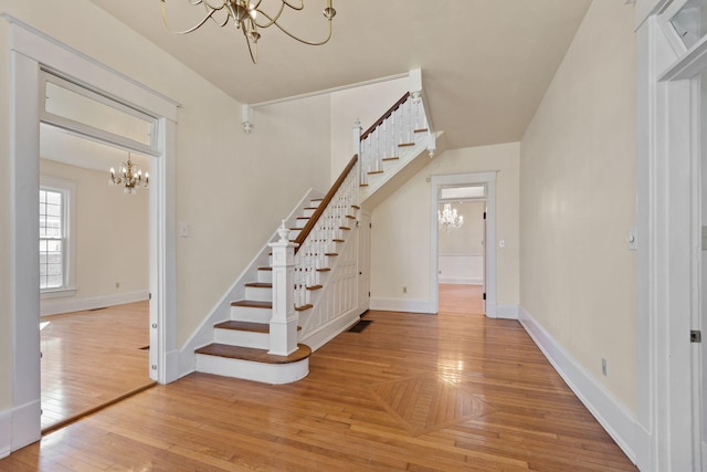 staircase featuring hardwood / wood-style flooring and an inviting chandelier